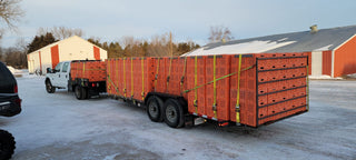 A photo of a truck and trailer loaded with orange Live Bird Transport boxes, showcasing the Cackle Box™ - 9" Double Wide ready for transport.
