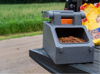 Chow box sitting on the tailgate of a truck filled with dog food