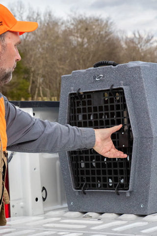 A man using Click's Easy Squeeze kit on a kennel door, showcasing the product's ease of use while outdoors.