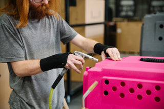 Employee working on pink RuffLand Kennel