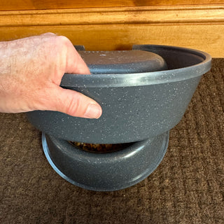 A hand demonstrating the stacking feature of RuffLand® Performance Kennels Dog Bowl with kibble showing inside.
