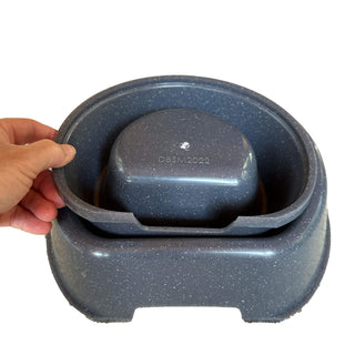 Hands holding a nested RuffLand® Performance Kennels Dog Bowl, showcasing its convenience for storage.